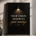 A framed motivational wall art print leaning against a wall on a marble surface. The print has a black background with a hanging light fixture illustration at the top and the text 'YOUR VISION DESERVES your courage.